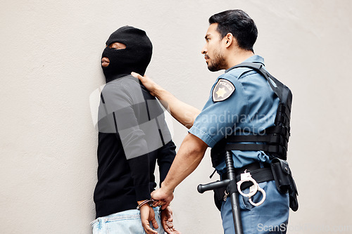 Image of Man, police and handcuffs on gangster for arrest, crime or justice in theft, robbery or violence. Male person, officer or security guard cuffing hands of robber, thief or criminal against the wall