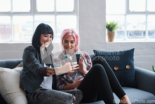 Image of Phone, social media and students with women friends sitting on a sofa in the campus breakroom at college. Education, university and young female pupils reading a text message while on break to relax