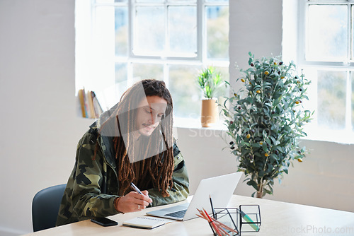 Image of Creative man, laptop and writing on desk with notebook for information, ideas or notes in startup at office. Male person working on computer in web design, planning or research on table at workplace