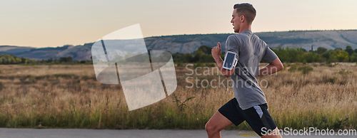 Image of A young handsome man running in the early morning hours, driven by his commitment to health and fitness