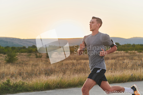 Image of A young handsome man running in the early morning hours, driven by his commitment to health and fitness