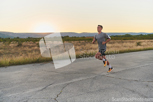 Image of A young handsome man running in the early morning hours, driven by his commitment to health and fitness