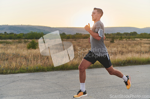 Image of A young handsome man running in the early morning hours, driven by his commitment to health and fitness