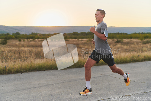 Image of A young handsome man running in the early morning hours, driven by his commitment to health and fitness