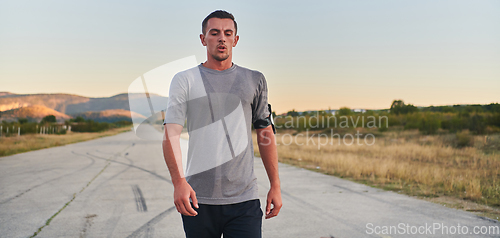 Image of A young handsome man running in the early morning hours, driven by his commitment to health and fitness