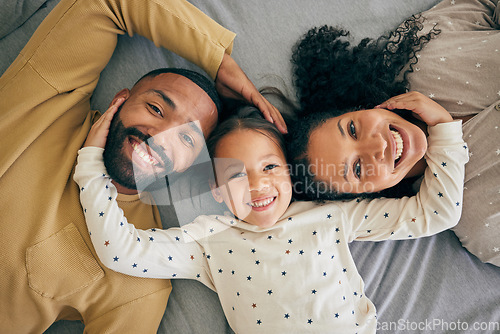 Image of Happy family, top view and child relax or happy with parents together in the morning laughing in a bedroom on a bed. Smile, mom and dad enjoy quality time with kid with happiness, bonding and love