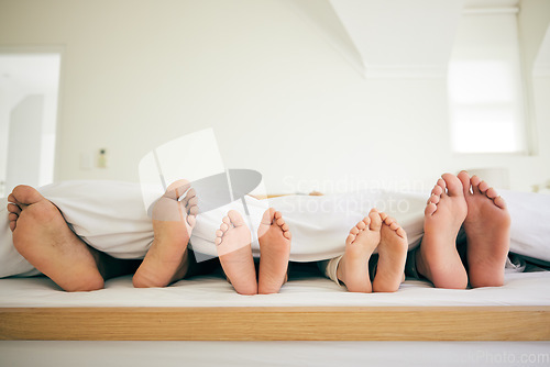 Image of Sleep, feet and family in a bed relax, resting and enjoying a weekend nap in their home. Sleeping, foot and children with parents in bedroom for dreaming, stress relief or vacation freedom in a house