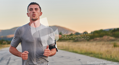 Image of A young handsome man running in the early morning hours, driven by his commitment to health and fitness