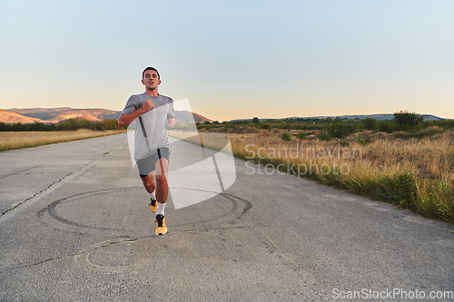Image of A young handsome man running in the early morning hours, driven by his commitment to health and fitness