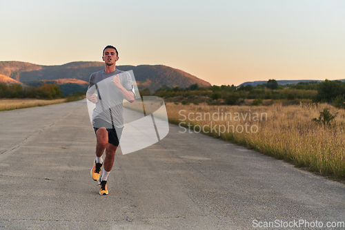 Image of A young handsome man running in the early morning hours, driven by his commitment to health and fitness