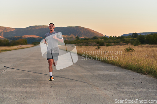 Image of A young handsome man running in the early morning hours, driven by his commitment to health and fitness