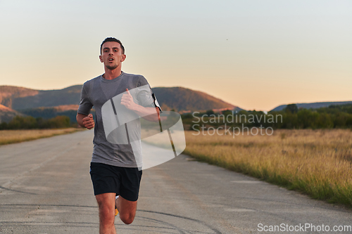 Image of A young handsome man running in the early morning hours, driven by his commitment to health and fitness