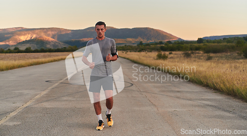 Image of A young handsome man running in the early morning hours, driven by his commitment to health and fitness