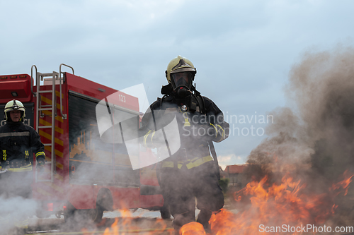 Image of Firefighters using water fog type fire extinguisher to fighting with the fire flame to control fire not to spreading out. Firefighter industrial and public safety concept.