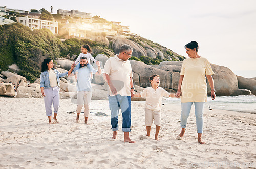 Image of Big family, holding hands and walking at a beach for travel, vacation and fun in nature together. Freedom, parents and children relax with grandparents at the sea on holiday, trip or ocean adventure