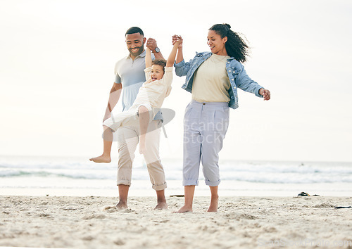 Image of Beach, family and holding hands outdoor for travel, freedom and bond in nature together. Love, fun and boy child with young parents at the sea with swing game, playing and happy on ocean holiday trip