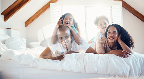 Image of Funny, family portrait and watching tv in bedroom, bonding and sunshine with lens flare. Face, television and children with father, mother and happy parents relax in home, streaming movie and laugh.