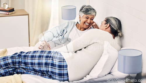 Image of Happy, laugh and senior couple relax in bed with love, bond and holding hands with conversation. Old people, bedroom and speaking with smile, trust and soulmate connection while enjoying retirement