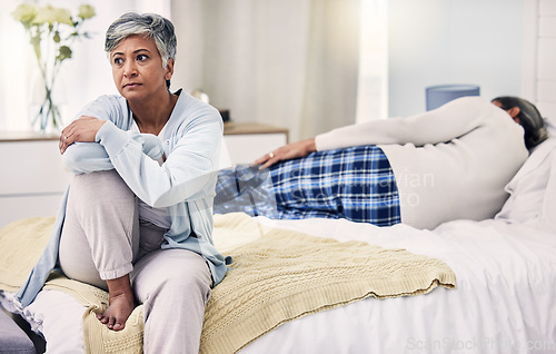 Image of Senior woman, divorce and sad in bedroom with depression or frustrated in marriage with infidelity. Fight, anxiety and elderly woman with problem in home or bed with problem and stress or angry.