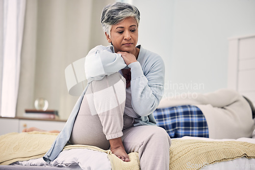Image of Divorce, sad and senior woman with depression in bedroom or frustrated with problem or fear. Infidelity, marriage and fight with elderly female with stress in home or angry with partner or couple.