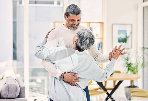 Image of Senior couple, hug and holding hands in dancing for love, care or bonding together in living room at home. Happy elderly man and woman enjoying quality time, retirement or celebration for anniversary