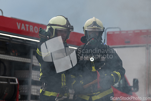 Image of Firefighters using water fog type fire extinguisher to fighting with the fire flame to control fire not to spreading out. Firefighter industrial and public safety concept.