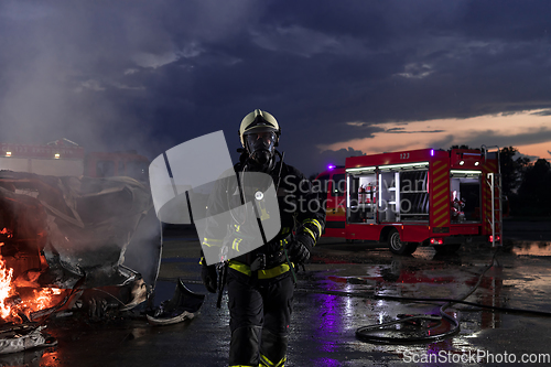 Image of Portrait of a heroic fireman in a protective suit. Firefighter in fire fighting or car accident rescue operation in dusk or night.