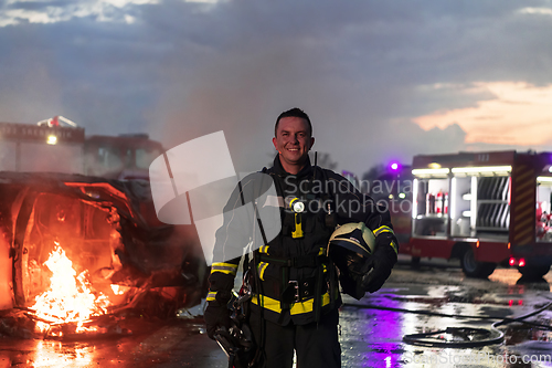 Image of Portrait of a heroic fireman in a protective suit. Firefighter in fire fighting or car accident rescue operation in dusk or night.