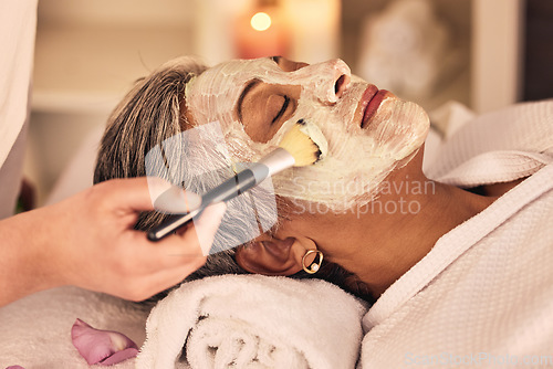 Image of Woman, spa and brush cream face mask for skincare treatment, relax or detox at beauty salon. Calm mature female client at wellness resort for facial cleaning, hydration cosmetics and peeling for glow