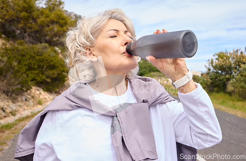 Image of Elderly woman, drinking water and bottle on road for fitness, running or thinking for vision, hydration or health. Mature lady, runner and detox with relax for wellness, exercise or workout in nature
