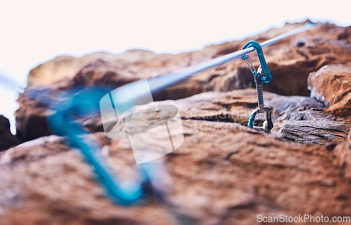 Image of Rock climbing, mountain and closeup of rope and hook for adventure, freedom and extreme sports in nature. Fitness, hiking and carabiner, equipment or gear in stone for training, activity or challenge