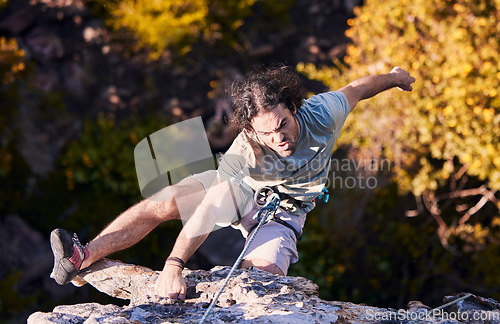 Image of Adventure, grab and sports, man rock climbing on mountain with cable for support and safety. Extreme workout, challenge and courage, climber on cliff with rope, commitment and fitness in nature.