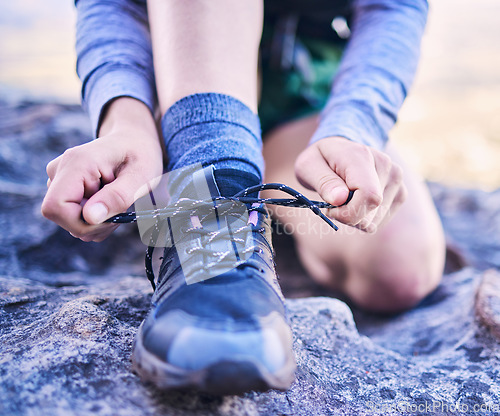 Image of Shoes, tying laces and a person for fitness, mountain hiking or start training for sports. Nature, exercise and closeup hands of an athlete with feet and ready for running, workout or cardio