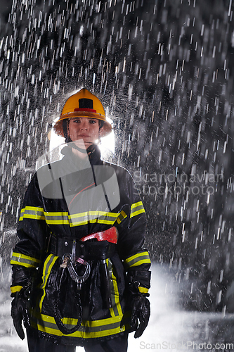 Image of A determined female firefighter in a professional uniform striding through the dangerous, rainy night on a daring rescue mission, showcasing her unwavering bravery and commitment to saving lives.