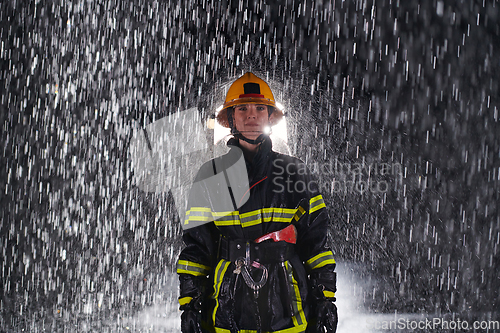 Image of A determined female firefighter in a professional uniform striding through the dangerous, rainy night on a daring rescue mission, showcasing her unwavering bravery and commitment to saving lives.