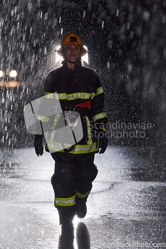 Image of A determined female firefighter in a professional uniform striding through the dangerous, rainy night on a daring rescue mission, showcasing her unwavering bravery and commitment to saving lives.