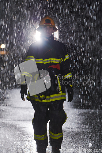 Image of A determined female firefighter in a professional uniform striding through the dangerous, rainy night on a daring rescue mission, showcasing her unwavering bravery and commitment to saving lives.