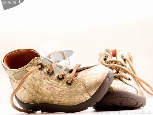 Image of Trendy little golden baby shoes  with copyspace