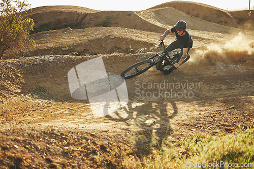 Image of Dust, mountain bike and man outdoor in nature for extreme sports, training or workout. Downhill, fitness and male person with courage or bicycle stunt for off road cycling, travel or adventure