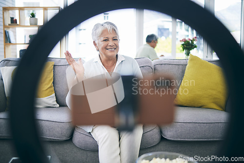 Image of Mature woman, live streaming and vlog in home for social media, chat broadcast or wave to audience online. Happy lady, content creator and filming digital podcast in living room, phone and ring light