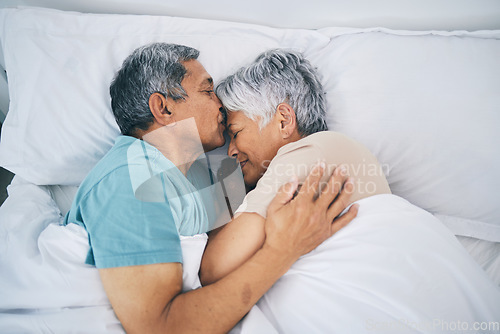 Image of Top view, hug and senior couple in bed, love and sleeping with retirement, wake up or happiness with a kiss. Romance, old man or elderly woman embrace, bedroom or holiday with marriage or loving