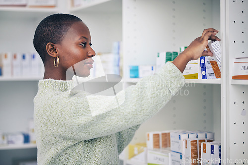 Image of Black woman, customer and box on shelf for pills, medicine or medication at the pharmacy. African female person or patient shopping pharmaceutical product or drugs for healthcare cure at clinic store