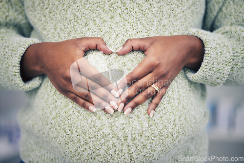 Image of Pregnancy, closeup and woman with a heart shape on her maternal belly for care and motherhood. Health, zoom and African pregnant female person hands on stomach with a love sign or emoji for her baby.