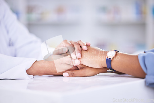 Image of Woman, pharmacist and holding hands for healthcare, support or trust on counter at the pharmacy. Closeup of female person or medical professional with patient in care for consultation, help or advice