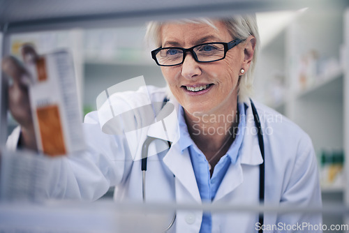 Image of Senior woman, pharmacist and reading medication on shelf for inventory, diagnosis or prescription at pharmacy. Happy mature female person, medical or healthcare professional checking medicine in shop