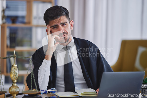 Image of Portrait, laptop and stress with a man judge in his law office looking confused about a trial or verdict. Computer, doubt or question with a magistrate sitting at his desk for legal problem solving