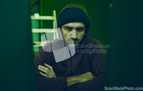 Image of Cybersecurity, crime and portrait of hacker in neon basement with code, fraud and online scam. Software criminal, serious and professional hacker on cyber attack, password thief with hoodie and tech.