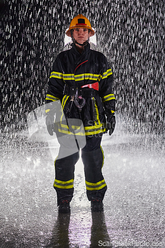 Image of A determined female firefighter in a professional uniform striding through the dangerous, rainy night on a daring rescue mission, showcasing her unwavering bravery and commitment to saving lives.