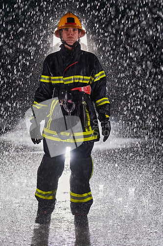 Image of A determined female firefighter in a professional uniform striding through the dangerous, rainy night on a daring rescue mission, showcasing her unwavering bravery and commitment to saving lives.