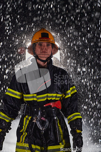 Image of A determined female firefighter in a professional uniform striding through the dangerous, rainy night on a daring rescue mission, showcasing her unwavering bravery and commitment to saving lives.